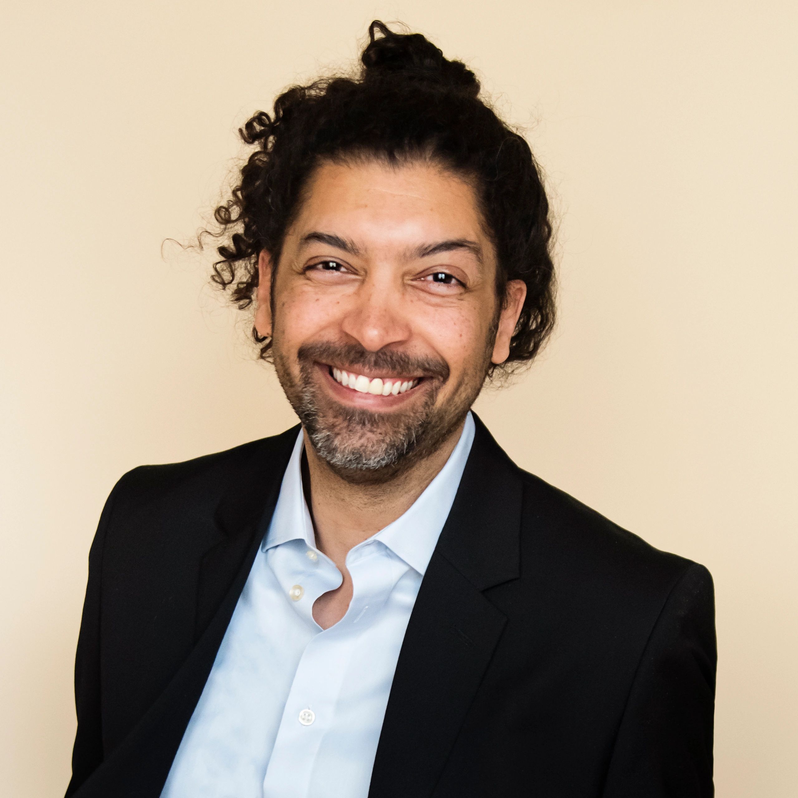 Portrait of stylish modern professional multiracial man on beige background.